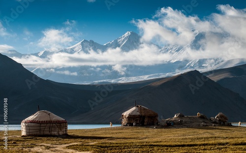 The yurt village in front of Karakul Lake in Xinjiang Uighur Autonomous Region of China is the highest lake of the Pamir plateau, with Muztagh Ata peak of the Kunlun mountains, in the background. photo