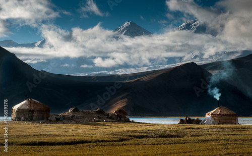 The yurt village in front of Karakul Lake in Xinjiang Uighur Autonomous Region of China is the highest lake of the Pamir plateau, with Muztagh Ata peak of the Kunlun mountains, in the background. photo