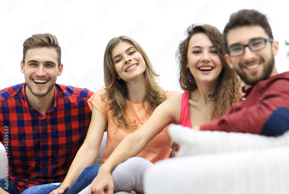 Obraz premium group of cheerful friends sitting on sofa