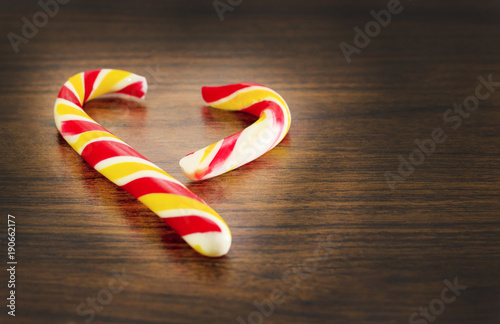 candy in the shape of heart on a wooden background for the celebration of Valentine's Day. Heart is broken. Cheating photo