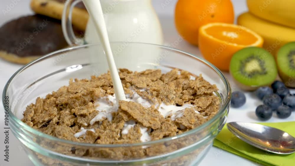 Pouring milk on cereals flakes for healthy and organic breakfast. Slow motion shot. Pouring milk on cereals flakes for healthy and organic breakfast. Slow motion shot.