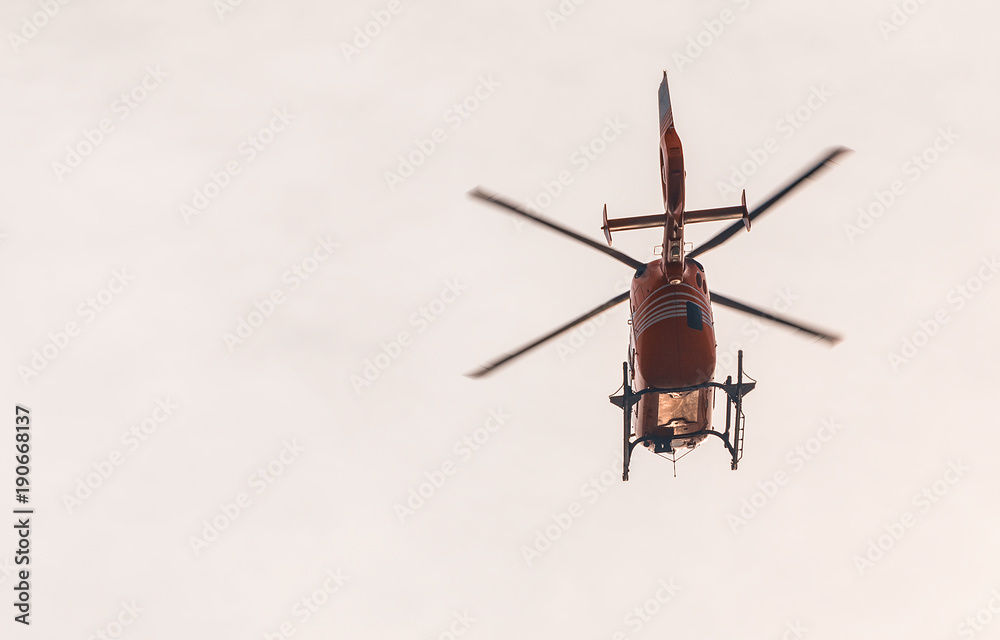 Red flying helicopter at sunset Red flying helicopter at sunset