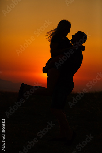 silhouette of guy and girl in the evening at sunset