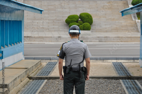 PANMUNJOM, SOUTH KOREA - SEPTEMBER 26, 2014: Korean soldiers watching border between South and North Korea in the Joint Security Area (DMZ) on September 26, 2014 in Panmunjom, South Korea. photo