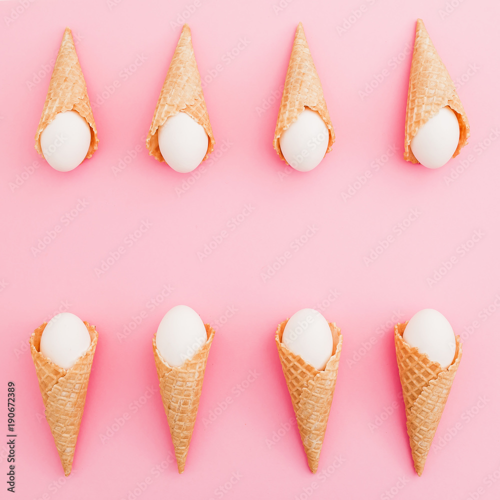 Stylish frame made of Easter white eggs in waffle cone on pastel pink background. Top view, Flat lay. Easter holiday concept. Stylish frame made of Easter white eggs in waffle cone on pastel pink background. Top view, Flat lay. Easter holiday concept.