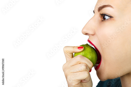 woman biting citrus fruit lime on white background
