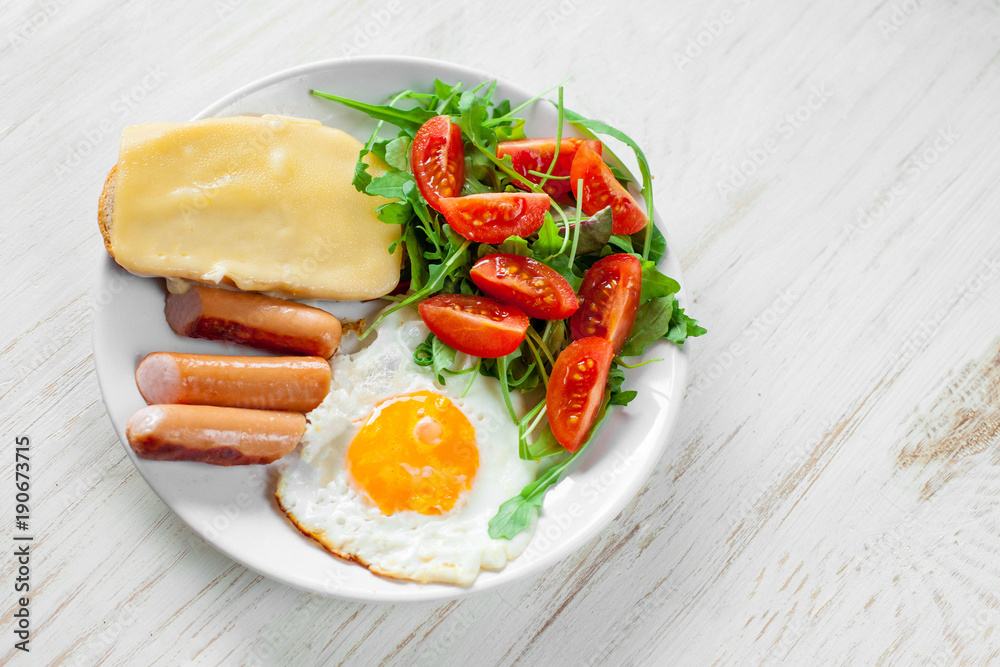 Breakfast which includes eggs, sausages, salad and toast with cheese Breakfast which includes eggs, sausages, salad and toast with cheese