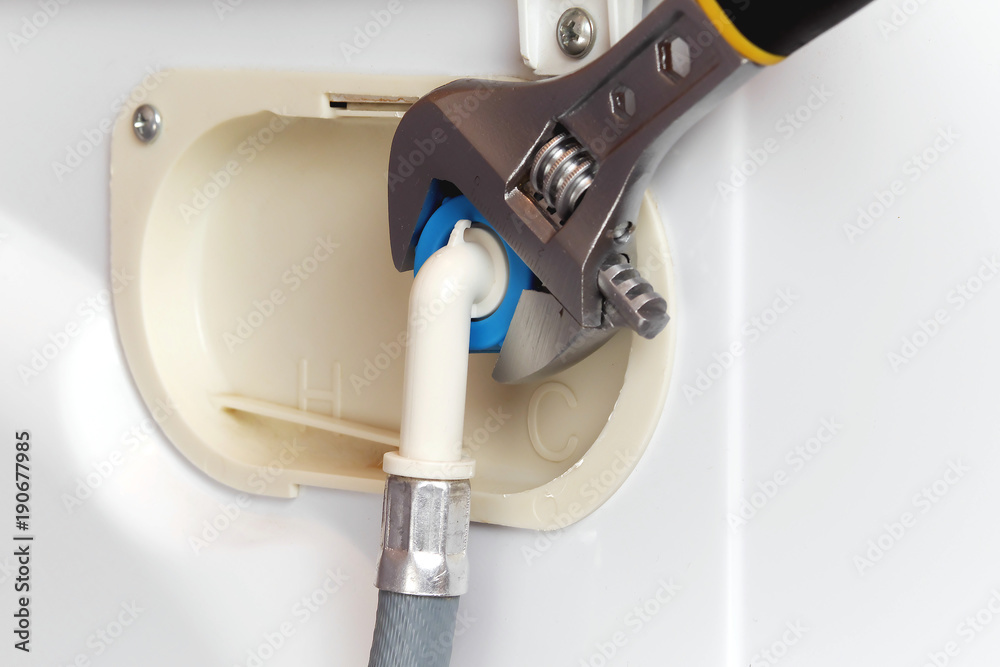 connecting water supply hose to washing machine using adjustable wrench connecting water supply hose to washing machine using adjustable wrench
