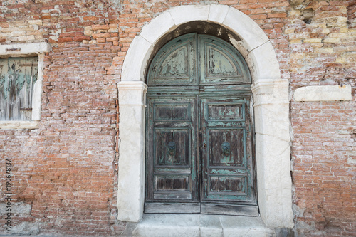 antique large decorative wooden door in a brick building © Rochu_2008