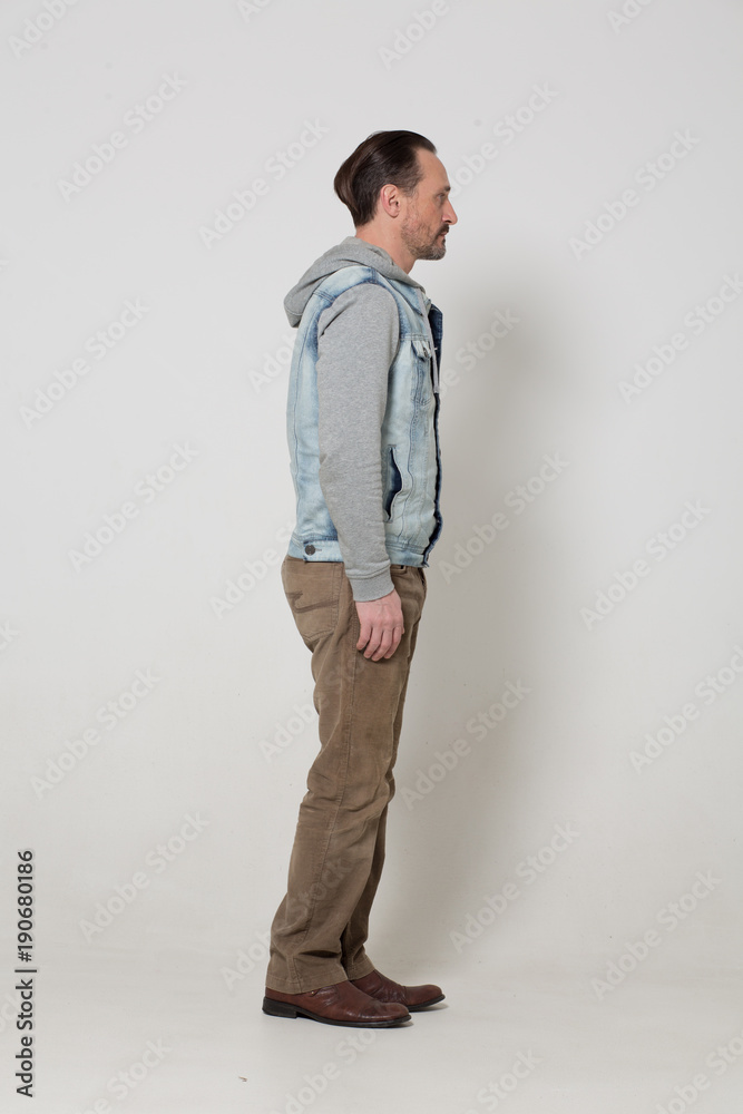 Sexy fit guy standing half turn on white wall background. Sexy fit guy standing half turn on white wall background.