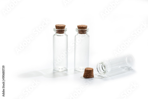 .Small glass bottles with cork lid on white background