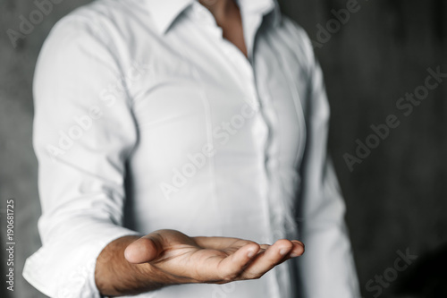 Businessman with open palm offering something. Close-up of young businessman's hand in concept of holding or giving.