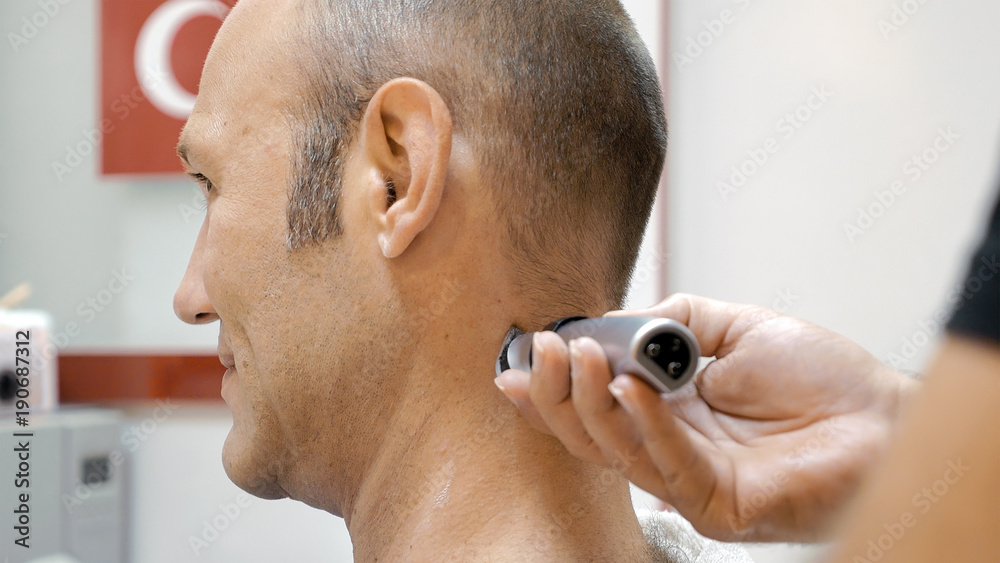 The barber is shaving his client in old fashion manner. Single blade shave gives the best result. Grooming is necessary for men and woman. The barber is shaving his client in old fashion manner. Single blade shave gives the best result. Grooming is necessary for men and woman.