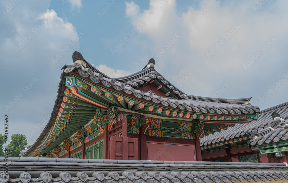 Colorful architecture, wooden roof and tile details, and modeled blue sky, at Gyeongbokgung Palace, Seoul, South Korea Colorful architecture, wooden roof and tile details, and modeled blue sky, at Gyeongbokgung Palace, Seoul, South Korea