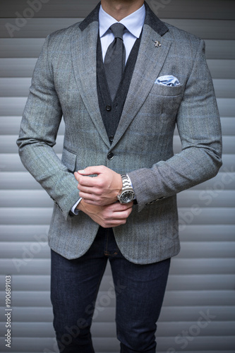 Man in suit posing and fixing his cufflinks