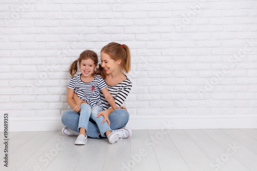 happy family mother and child daughter near an empty wall © JenkoAtaman