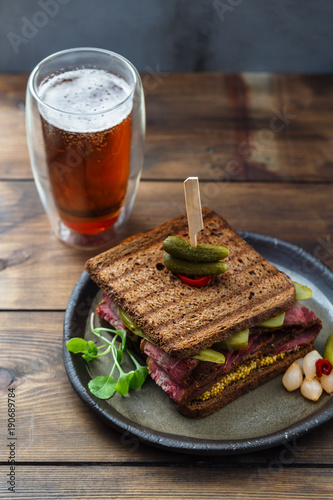 Pastrami sandwich with mustard and pickle photo