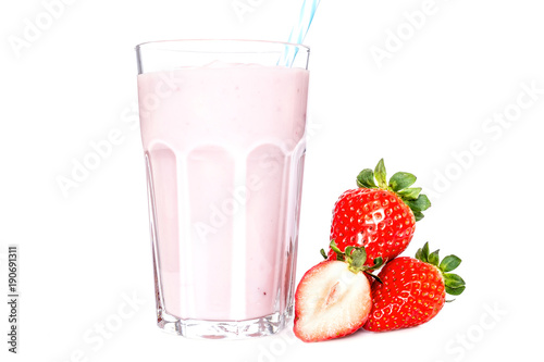 Strawberry next to a glass of strawberry yogurt close-up isolated on a white background