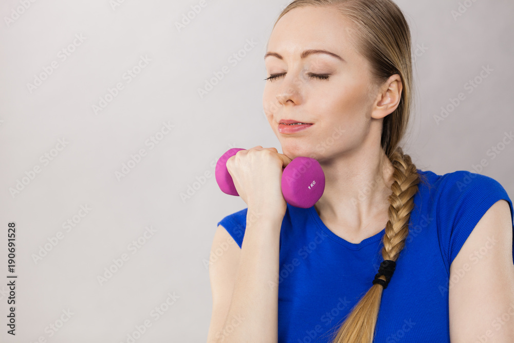 Teenage woman working out at home with dumbbell Teenage woman working out at home with dumbbell