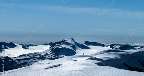 Man coming over the hill, seen from Glittertind. Galdhopiggen behind. Jotunheimen, Norway.