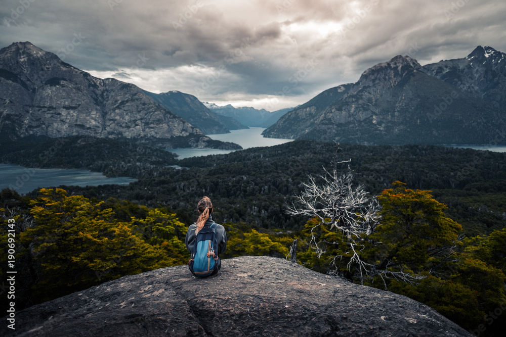 Woman hiker enjoys the valley view from viewpoint. Area near the city of Bariloche, Argentina