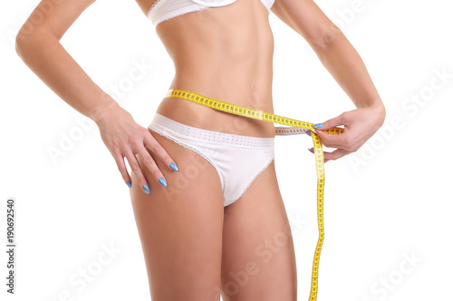 girl in white underwear measures her waist
