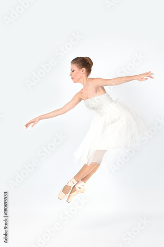 the ballerina in pointes and a white dress dances on a white background