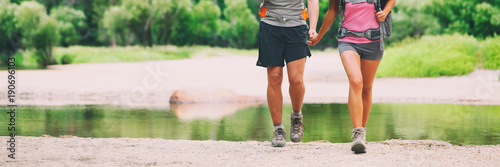 Adventure travel in amazing nature landscape. Couple tourists enjoying freedom on vacation at waterfall banner panorama . People with open arms in success, summer holiday in Iceland.