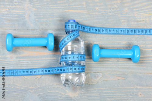 Water and measuring tape and dumbbells, top view