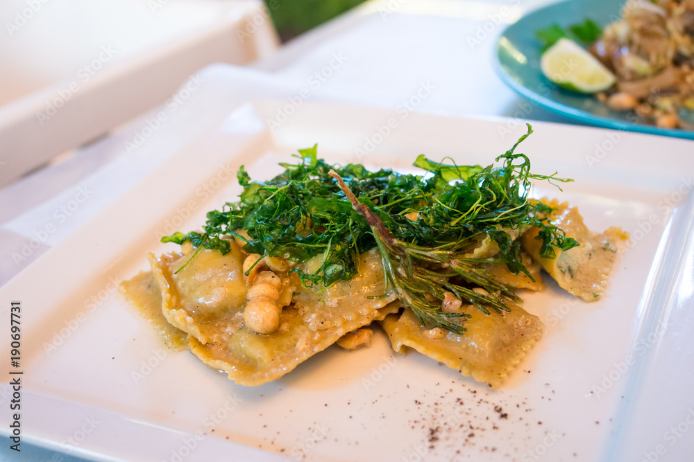 Ravioli with ricotta cheese, rucola and hazelnuts in italian restaurant