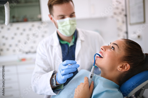 Female with dental sucker on chair in ordination