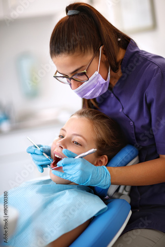Female dentist repairing child s tooth