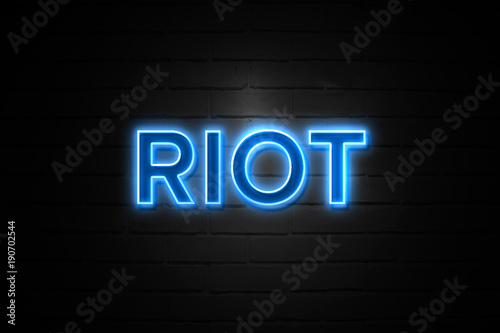 Riot neon Sign on brickwall