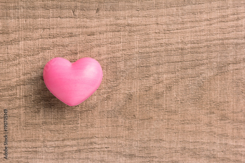 Red heart shape over wooden table. Overhead of romantic symbol of valentine day for background use. Concept of love, romance, and passion.