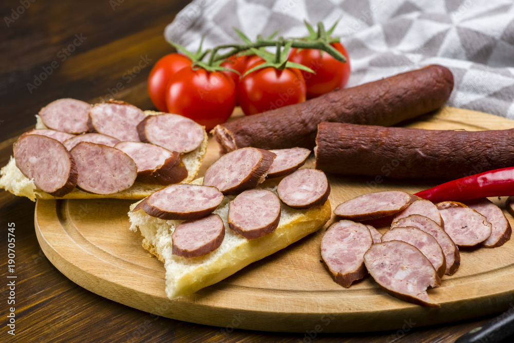 Sandwiches with homemade smoked sausage located on a board - food for consolation - tasty and healthy Sandwiches with homemade smoked sausage located on a board - food for consolation - tasty and healthy