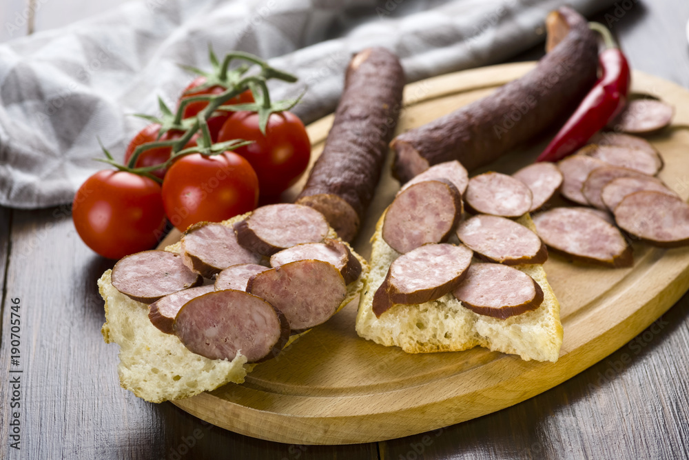 Sandwiches with homemade smoked sausage located on a board - food for consolation - tasty and healthy
