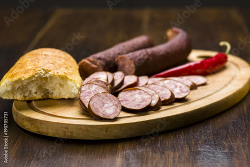 Homemade smoked sausage sliced on wooden board