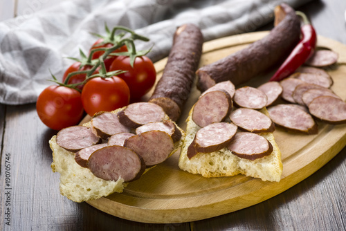 Sandwiches with homemade smoked sausage located on a board - food for consolation - tasty and healthy
