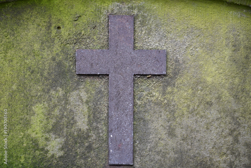 Weathered christian cross on a tombstone