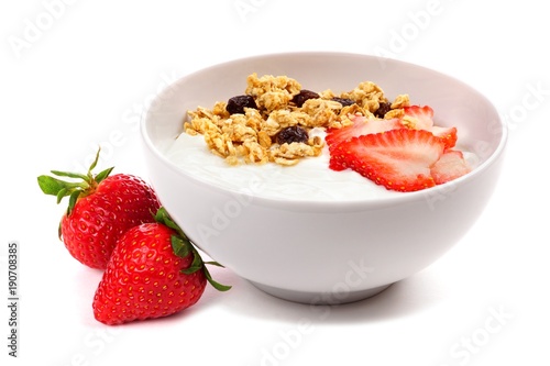 Yogurt with strawberries and granola in a white bowl. Side view, with berries isolated on a white background.