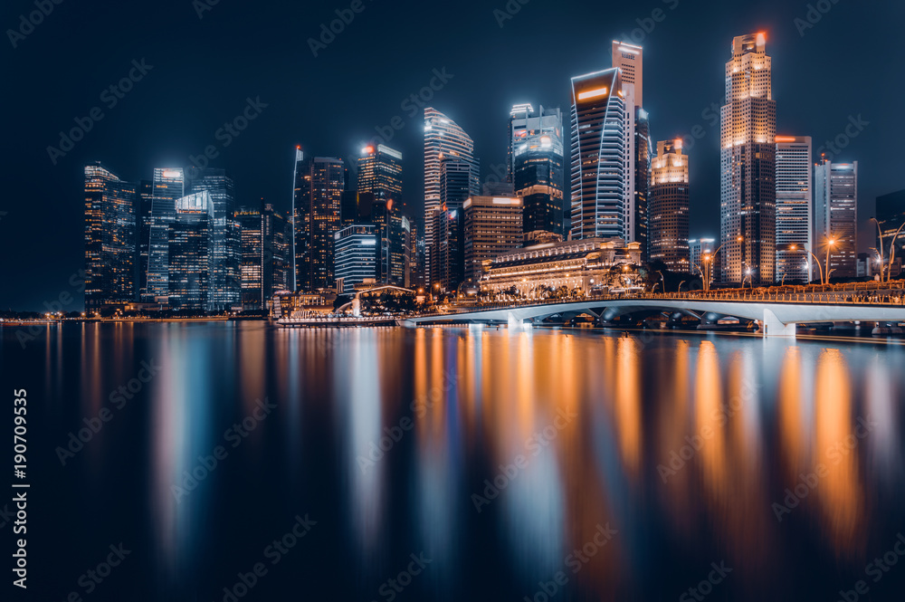 Naklejka premium Panoramę miasta Singapur. Widok dzielnicy biznesowej. Śródmieście odbite w wodzie w nocy w Marina Bay. Pejzaż miejski