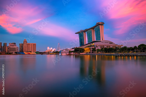 Photography Famous landmark Marina Bay Sands hotel reflected in water at pink sunset