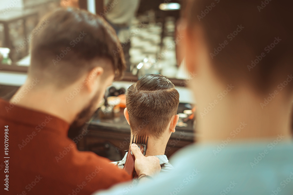 Barbershop. Close-up of man haircut, master does the hair styling in barber shop. Toned vintage photos. Barbershop. Close-up of man haircut, master does the hair styling in barber shop. Toned vintage photos.