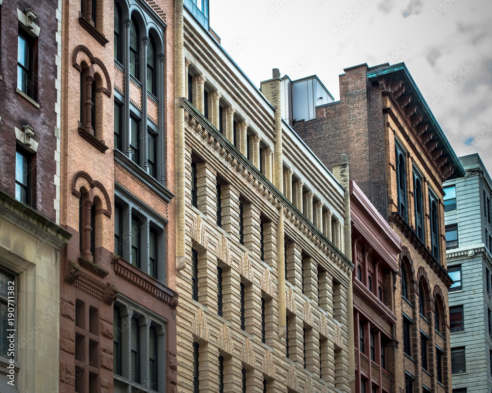 Row of vintage New York City apartment buildings in a variety of brick and brownstone facades