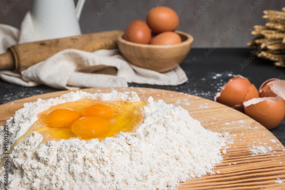 Eggs, dough, flour and rolling-pin on wooden table background. Preparation for making homemade ravioli pasta Eggs, dough, flour and rolling-pin on wooden table background. Preparation for making homemade ravioli pasta