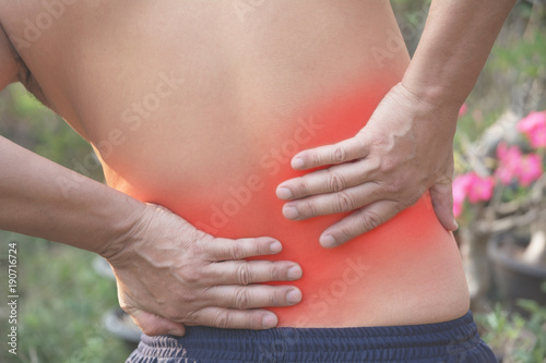 Wallpaper Mural Man with hands holding his waist back in pain. A man pain concept with red spot. Torontodigital.ca