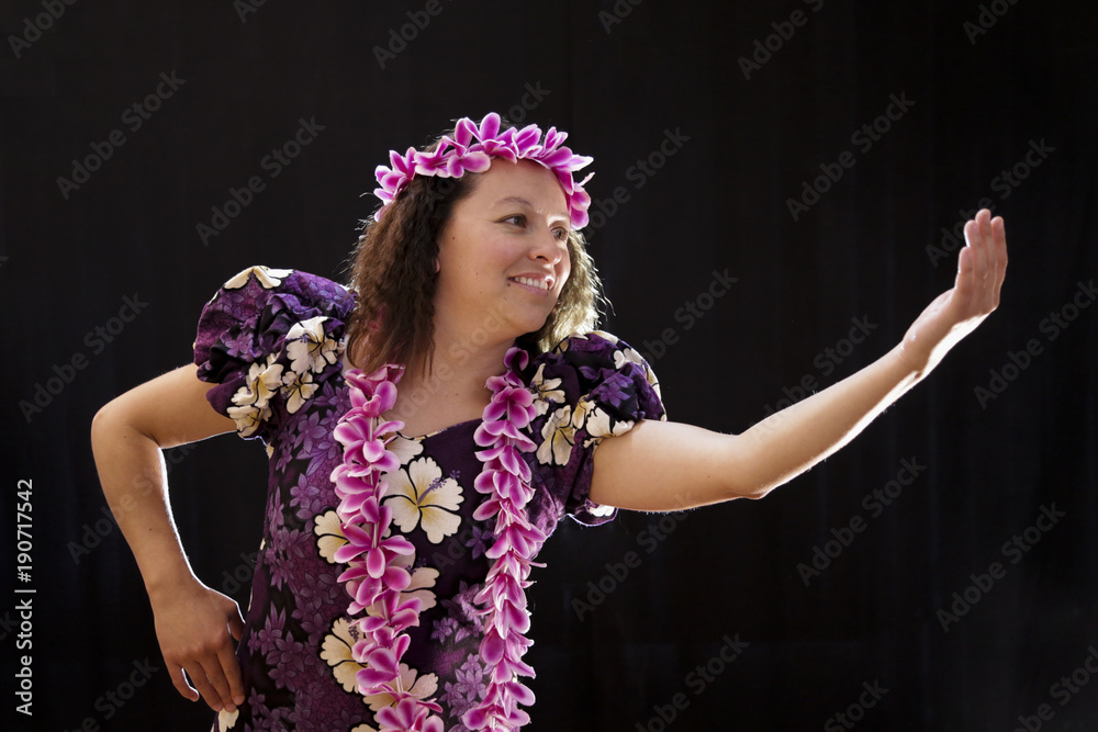 Fototapeta premium Smiling female Hawaiian girl dancing and singing with musical instruments like the ukulele