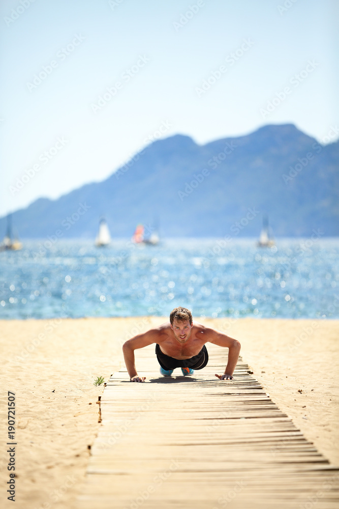 Sport beach fitness man doing push-ups. Handsome athlete training push up topless outside in summer sun. Fit male fitness model doing exercise outdoors. Healthy lifestyle concept. Active lifestyle.