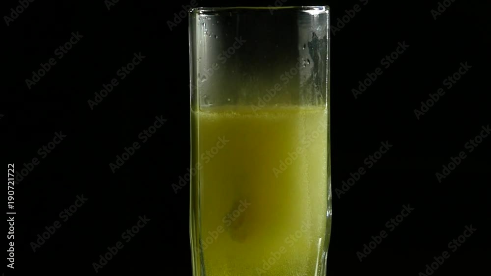 Close-up effervescent tablet in glass of water dark background, slow motion Close-up effervescent tablet in glass of water dark background, slow motion