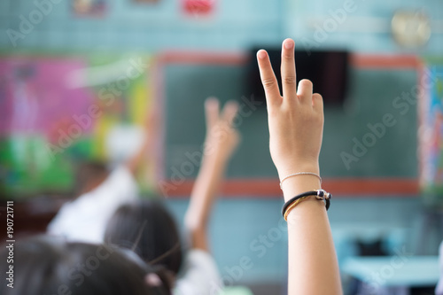 Student hands up answer a question in class at the elementary school. Education concept. © narongchaihlaw
